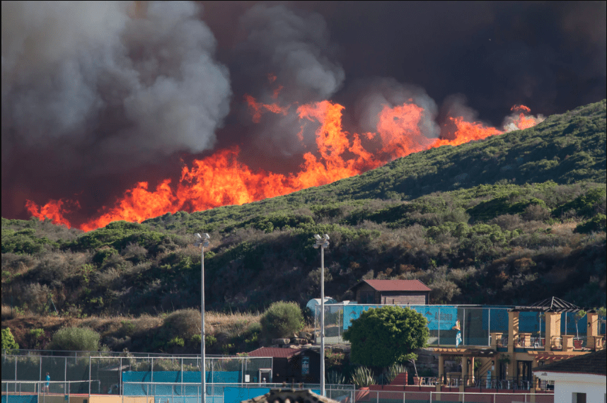 Wildfire encroaches upon a cluster of buildings